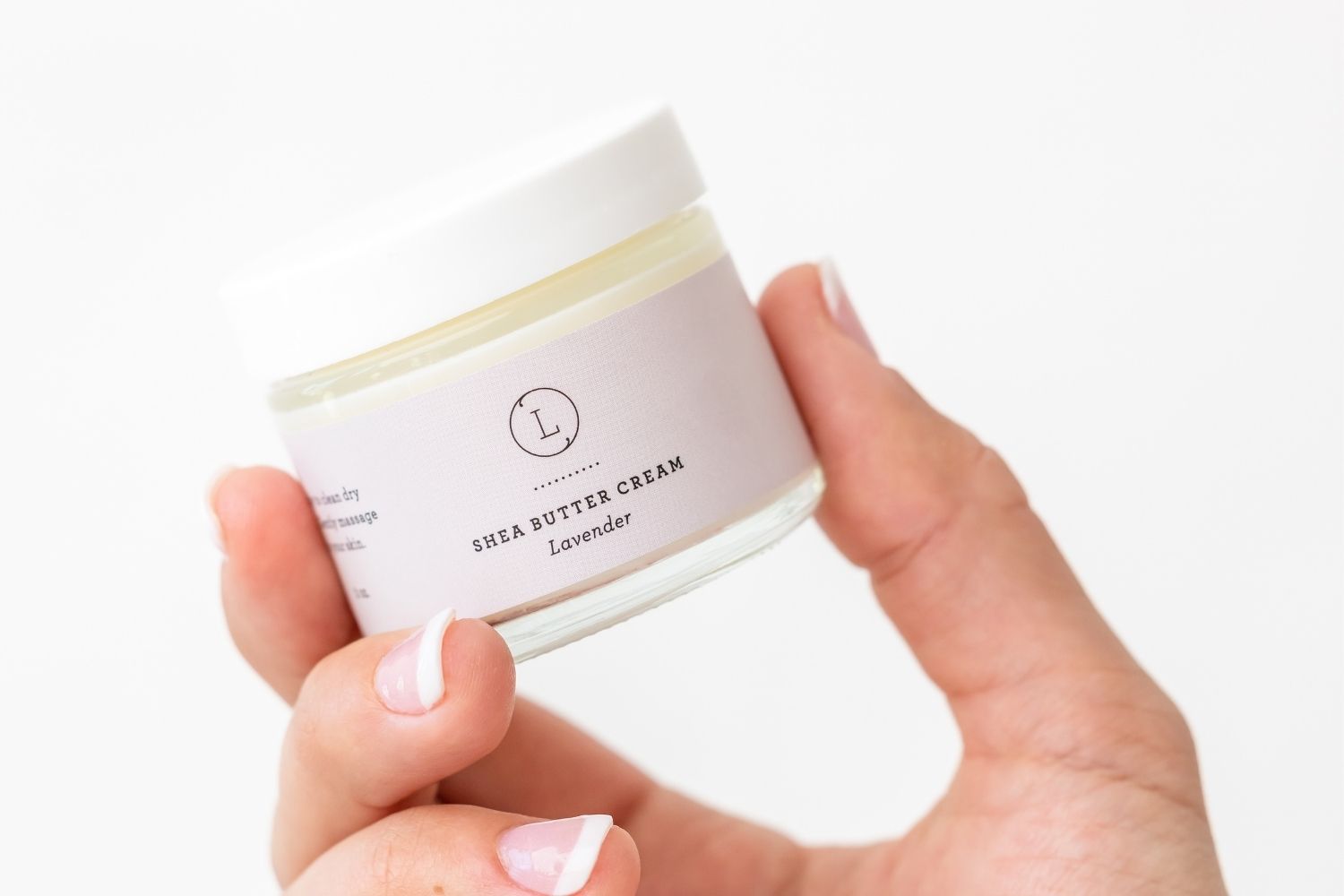 Hand holding a jar of CBD Lavender Shea Butter Cream, a natural moisturizer for dry skin.