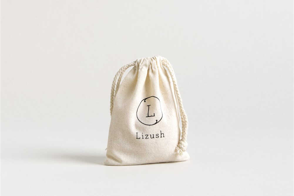 Lizush branded cotton drawstring bag for natural skincare products, eco-friendly packaging design.